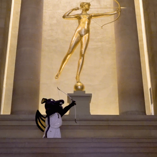 Animation of Mario the Dragon with a bow and arrow in front of the statue of Diana